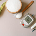 Imagem conceitual sobre diabetes com açúcar, medidor de glicose, fita métrica e caneta de insulina, representando controle e prevenção da doença