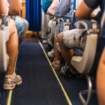 Passageiros sentados em um avião durante voo, representando o risco de trombose em viagens longas e a importância de cuidar da circulação.